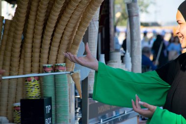 İstanbul, Türkiye - 24 Haziran 2022: Türk dondurma satıcısı şakaları ve müşteriler eğleniyor. Geleneksel Türk dondurması satışları.