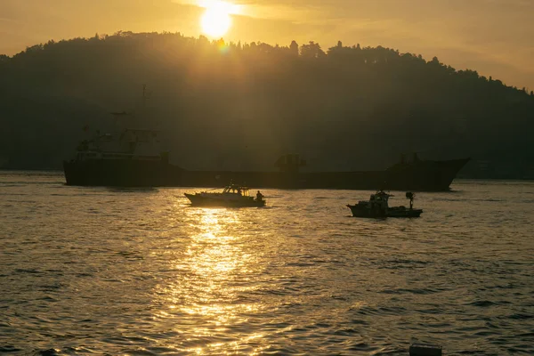 Men on a boat in Bosphorus waters in Istanbul. Fisherman in boat in Istanbul. Turkish fisherman sailing in boat in sea.