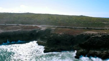 Profesyonel bisiklet yarışçıları okyanus kıyısında yol boyunca bisiklet sürerler. Okyanus boyunca otoban.