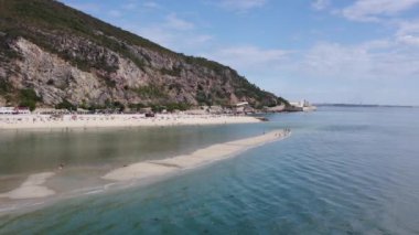 Kumlu Portekiz adaları. Dağları olan okyanus kıyısı. Deniz tükürüğünün havadan görünüşü. Rocky Sahili Tırpanı.