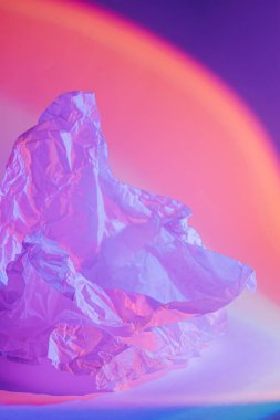 Neon ışığı altında buruşmuş kağıtla soyut arkaplan.