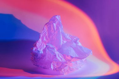 Neon ışığı altında buruşmuş kağıtla soyut arkaplan.