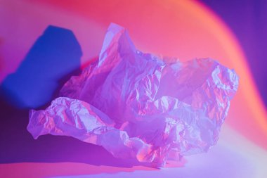 Neon ışığı altında buruşmuş kağıtla soyut arkaplan.