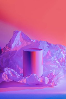 Neon ışıkta buruşmuş kağıtlı silindir podyum. Ürünleri göstermek için stil sahibi geometrik şekiller. Soyut arkaplan 