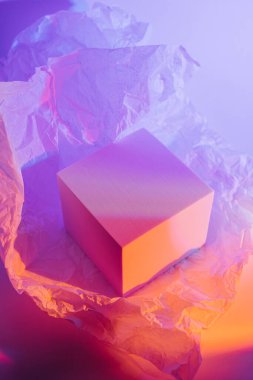 Kırışmış kağıtlı, neon ışıklı küp podyum. Ürünleri göstermek için stil sahibi geometrik şekiller. Soyut arkaplan 