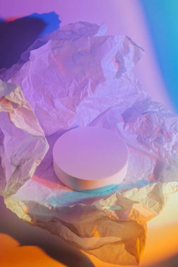 Buruşuk kağıtlı, neon ışıklı bir podyum. Ürünleri göstermek için stil sahibi geometrik şekiller. Soyut arkaplan 