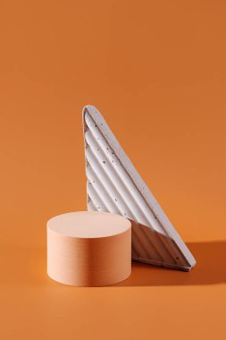Kozmetik ürünleri göstermek için geometrik beton figürlü podyum. Markalaşma ve paketleme sunumu için bej rengi arkaplan.
