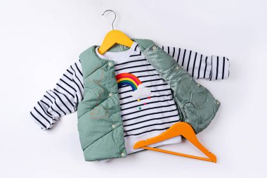 Beyaz arka planda çizgili kazaklı yelek. Şık çocuk kıyafetleri var. Moda çocuk kıyafeti.