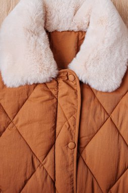 Kürk yakalı yorgan ceketli. Kahverengi arka plan dokusu. Yakın plan.