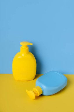 Mavi arka planda sabun ya da şampuan şişeleri. Boş şişe ambalajı tasarla.