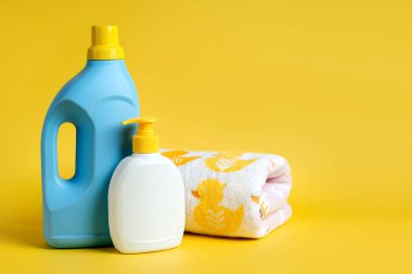 Çocuk kıyafetleri için deterjan ve mavi arka planda sabun şişeleri. Boş şişe ambalajı tasarla.