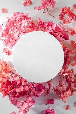 Boş yuvarlak kart ve pembe çiçekler. Tasarım ve sunum için şık arka planda sahte kart. Şenlik ve bahar kutsanması. Anneler günü kartı mı, kadınlar günü mü?