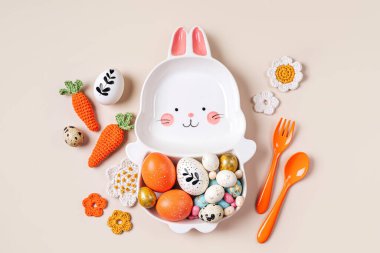 Paskalya sofrası, paskalya yumurtası, şeker, havuç ve çiçeklerle süslü şirin bir tabakla süslenmiş. Mutlu Paskalyalar. Paskalya yemeği için fikir