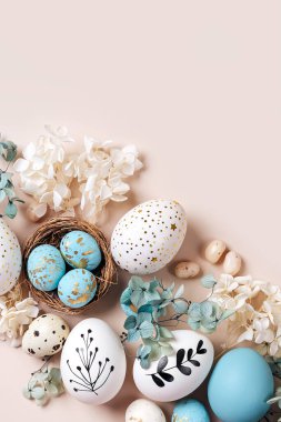 Tatlı ve bej çiçekli Paskalya yumurtaları. Mutlu Paskalyalar. Beyaz ve mavi yumurtalar ve şekerli şirin bir yuva 