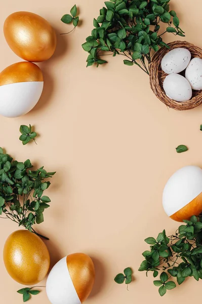 Yeşil çiçeklerden ve Paskalya altın yumurtalarından yapılmış bir çerçeve. Tatil konsepti. Mutlu Paskalyalar Kartı