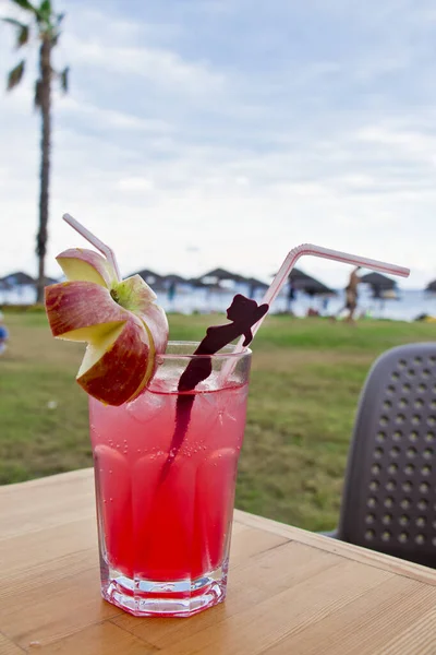 An ice cold rose cocktail with apple in the evening on the beach in turkey