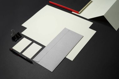 Kırtasiye modeli şablonu kırmızı A4 Letterhead, kartvizit, zarf, kitap kalemi. Koyu arkaplan gerçek fotoğraf