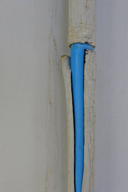 Eski ve kirli mavi plastik su borularını kapatın. Binada hasar var. Boşluğu kopyalayın.