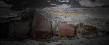 Beton yüzeyinde soyulmuş boya olan eski bir duvar.