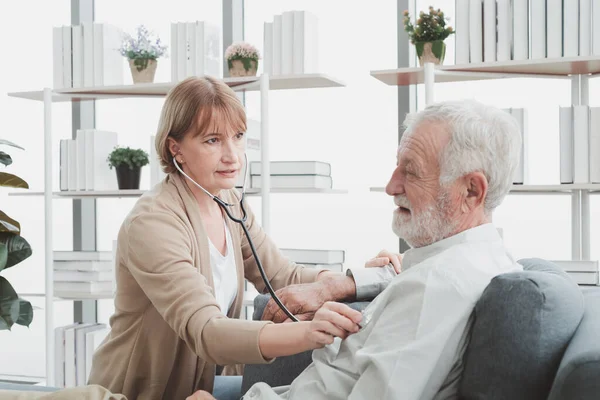 Yaşlı kadın doktor hastasıyla oturuyor ve sağlık kontrolü yapıyor..