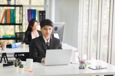 İş adamı resmi yönetici görünümlü bir adam modern iç işlerinde gülen ve mutlu duygularla çalışan takım elbiseli biri..