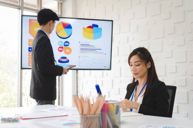 Business people in formal suit meeting with team coworker presentation with graph and chart in modern meeting room.