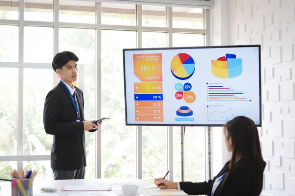 Business people in formal suit meeting with team coworker presentation with graph and chart in modern meeting room.