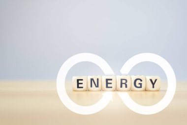 Renewable energy concept of infinity power wood cube with ENERGY word on wood table with clear background.