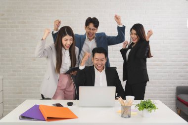 Business Asian people in formal outfit working together and being success and winning from company profit in office workplace room.