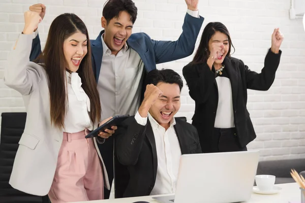 Business Asian people in formal outfit working together and being success and winning from company profit in office workplace room.