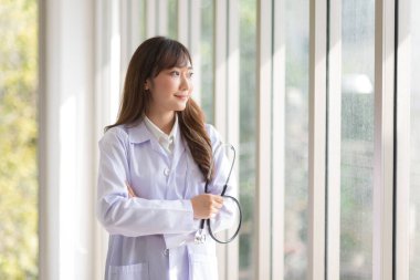 Asian doctor woman portrait in professional uniform standing with smile and confidence.