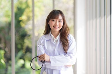 Asian doctor woman portrait in professional uniform standing with smile and confidence.