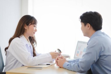 Asian doctor woman in white professional lab coat examining and diagnose the patient in modern room.