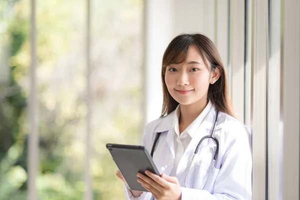 Asian doctor woman portrait in professional uniform standing with smile and confidence.