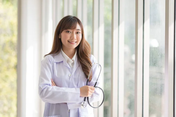 Asian doctor woman portrait in professional uniform standing with smile and confidence.