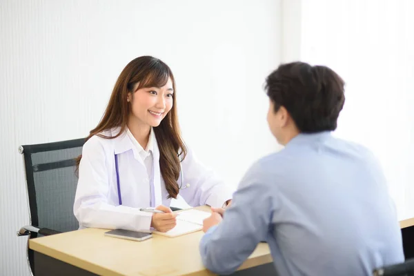 Asian doctor woman in white professional lab coat examining and diagnose the patient in modern room.