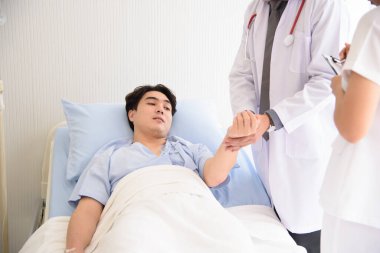 Doktor ve hemşire yataktaki semptomlarla ilgileniyorlar..