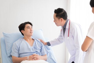 Doktor ve hemşire yataktaki semptomlarla ilgileniyorlar..