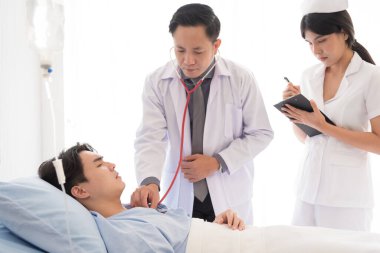 Doktor ve hemşire yataktaki semptomlarla ilgileniyorlar..