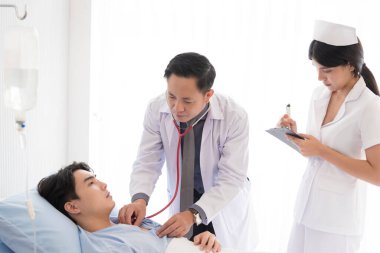 Doktor ve hemşire yataktaki semptomlarla ilgileniyorlar..