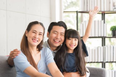 Mutlu anne baba ve kızının portresi. Kanepede birlikte oturup evde dinleniyorlar..