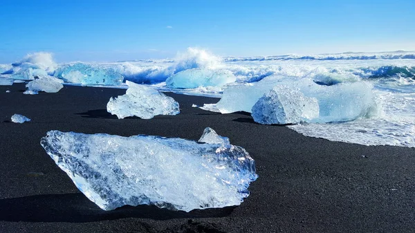 Dalgalar İzlanda 'daki Jokulsarlon plajında buzullara çarpıyor.