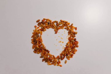 Beyaz arka planda kırmızı arnavut biberiyle yapılmış kalp şekli.