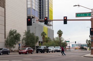 Phoenix şehir merkezinde genç bir adam sokakta paten kayıyor.