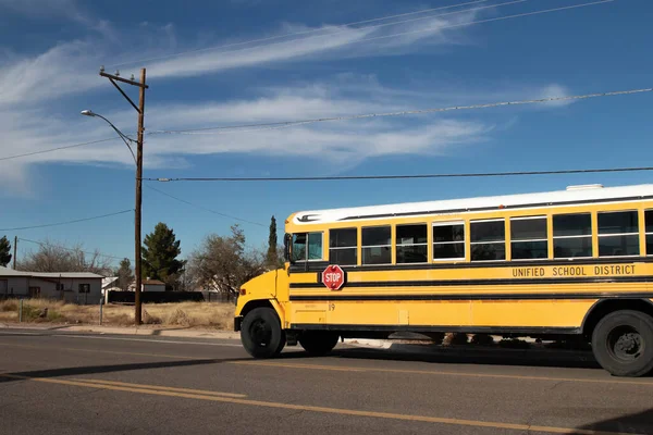 Autobús escolar se detuvo en la parada de autobús para recoger a los niños bajo el cielo azul — Foto de Stock