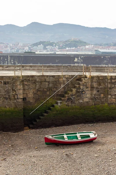 Κόκκινο και πράσινο σκάφος εγκαταλειφθεί στην παραλία — Φωτογραφία Αρχείου
