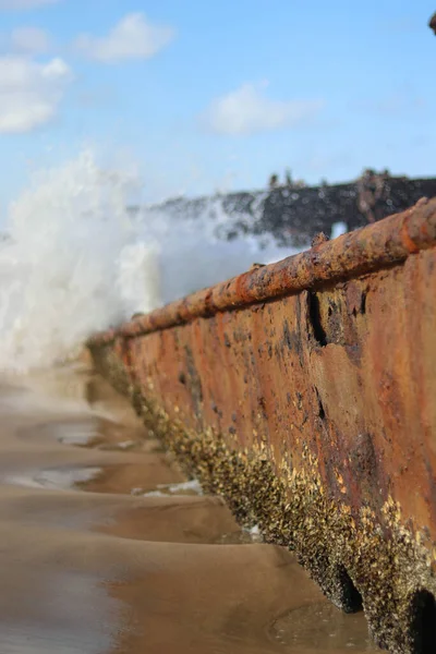 Meereswellen zertrümmern das Wrack eines verrosteten Schiffswracks — Stockfoto