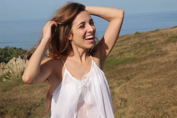 Porträtt av en glad ung kvinna som ler på ett fält — Stockfoto