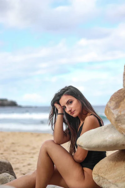 Belle femme brune sur la plage appuyée sur son bras avec une jambe courbée — Photo