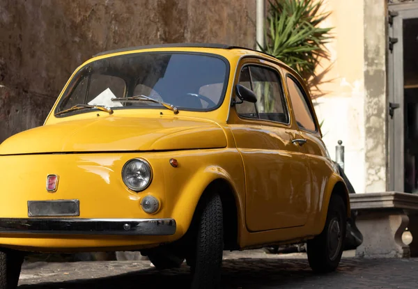 Front view of small vintage and antique yellow car in european old city streets — Stock Photo, Image